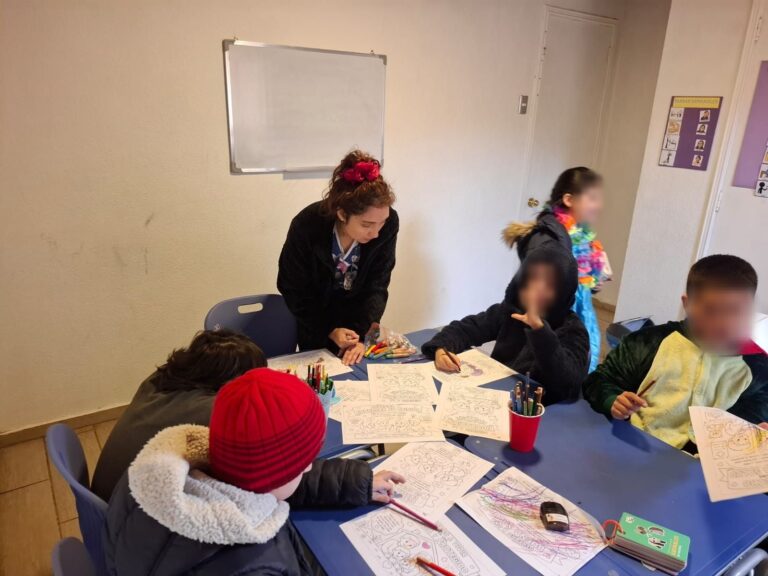Niños y profesoras trabajando juntos en la sala