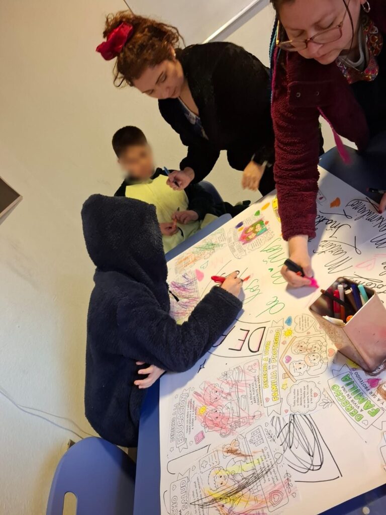 Niños y profesoras pintando un mural en taller